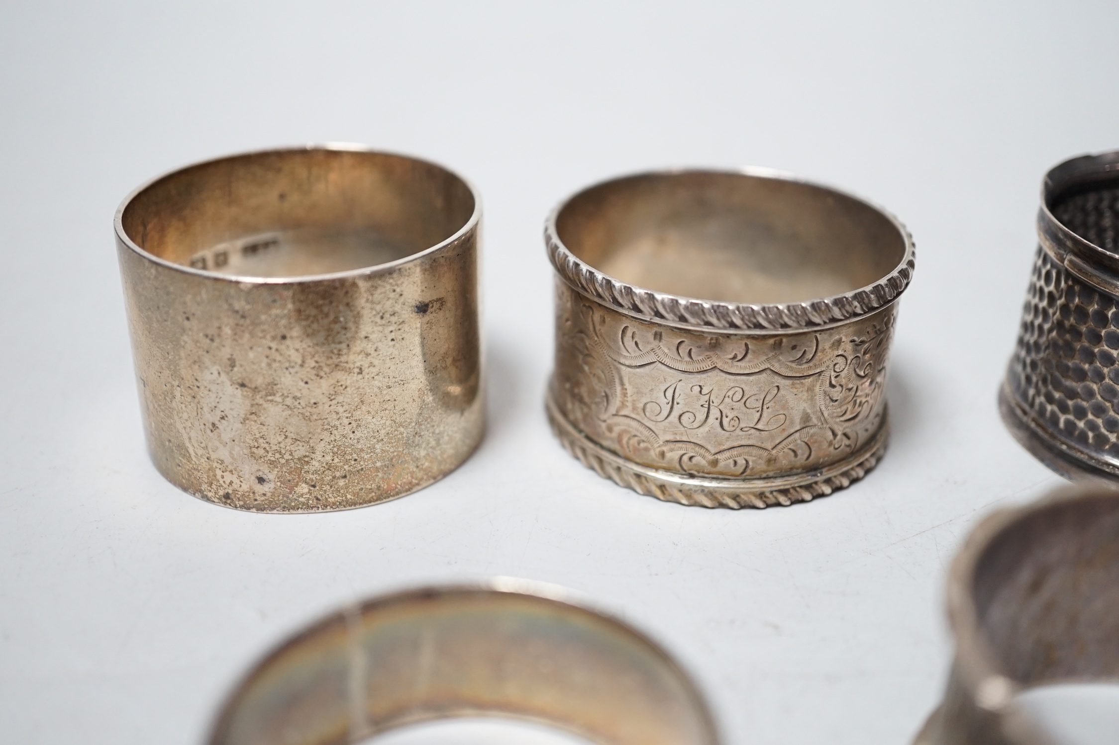 Five assorted silver napkin rings.